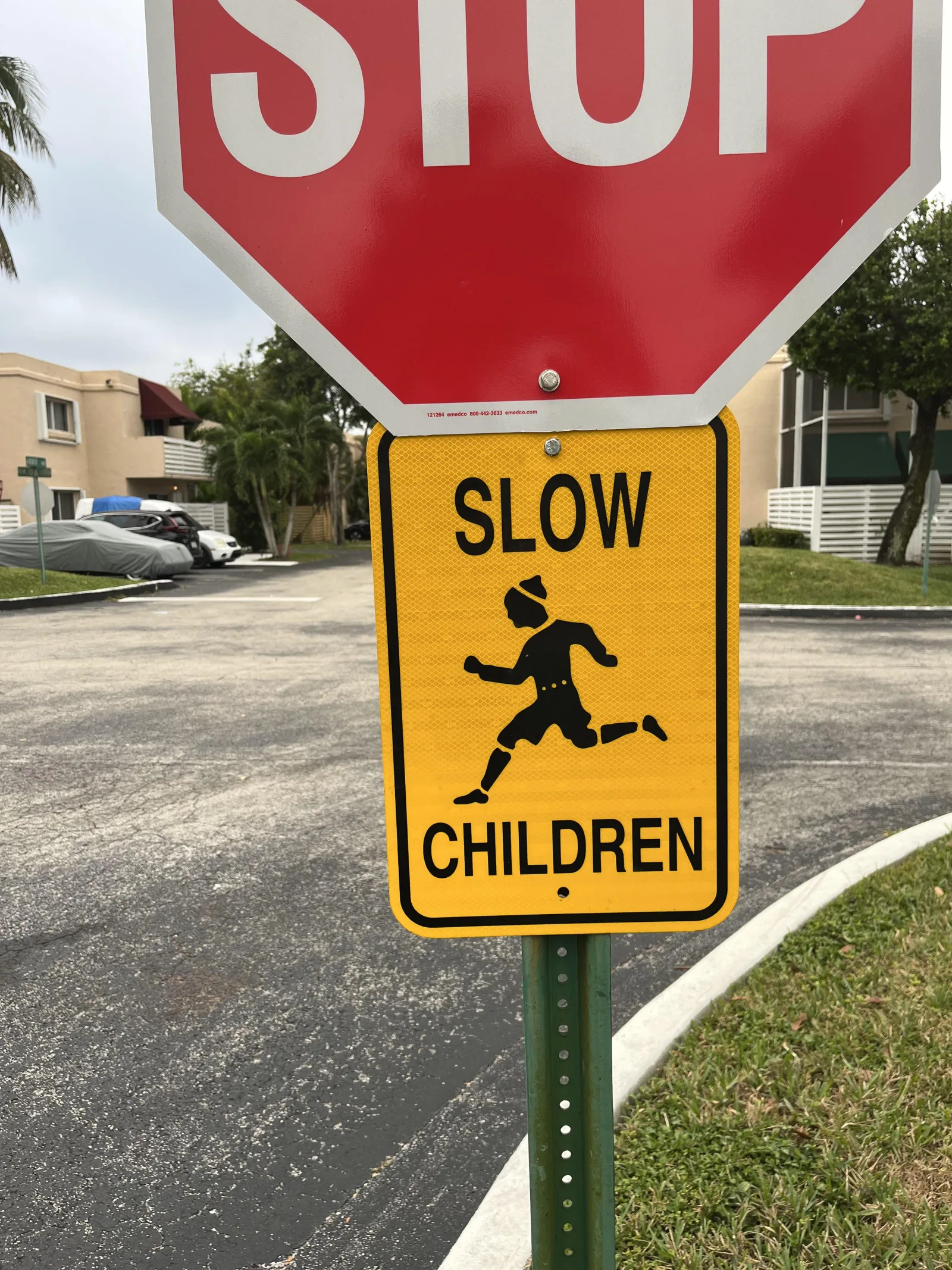 A Slow Children warning sign beneath the cropped edge of another road sign