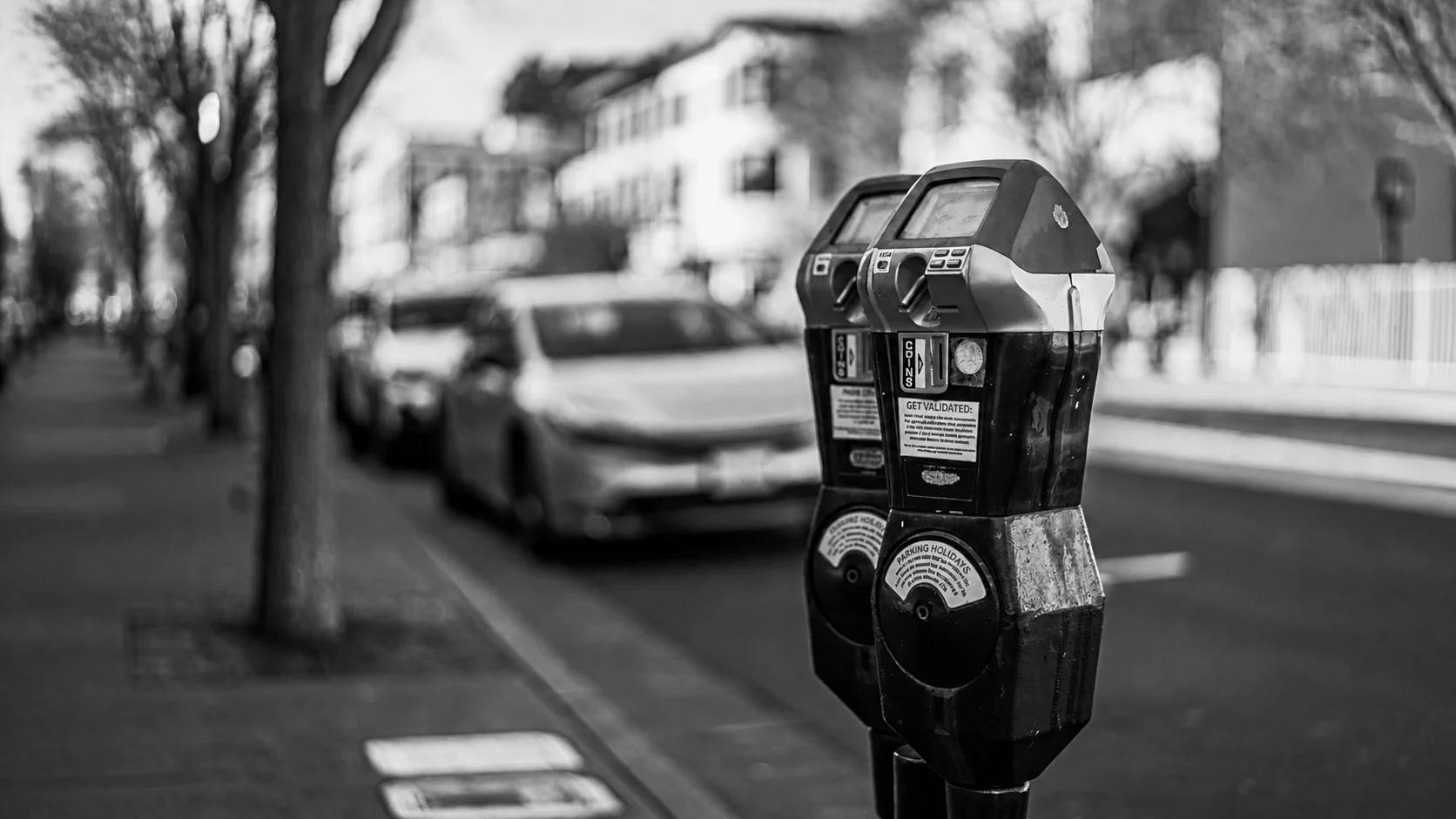 Two coin-operated parking meters beside a city street